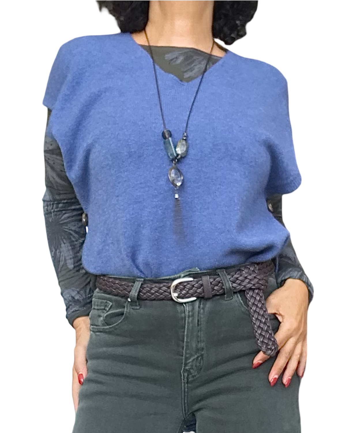 Débardeur en tricot bleu jeans col V porté en superposition sur un haut imprimé, avec long collier et ceinture tressée