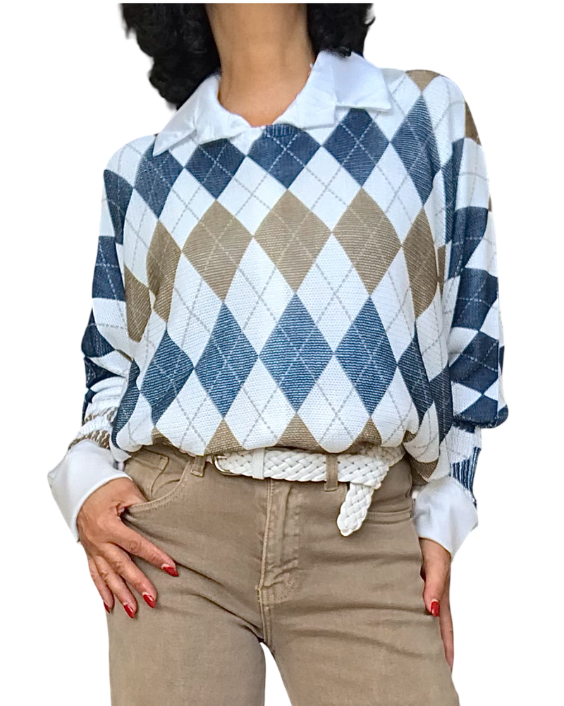 Chandail en mailles à losanges marine, blanc et noisette porté sur une chemise blanche avec pantalon beige