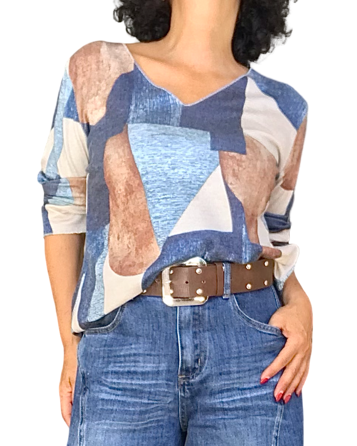 T-shirt col V à motif géométrique beige, camel, bleu jeans et marine porté avec ceinture brune et jeans bleu