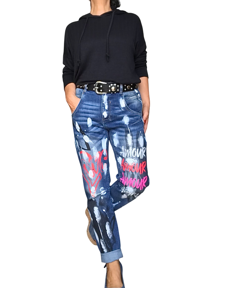 Jeans boyfriend avec écritures blanches, rouge et rose et des taches blanches et noires