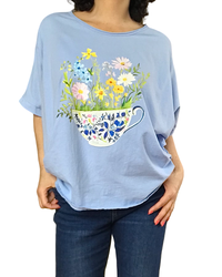 T-shirt uni bleu ciel col rond, manche courte, avec un bouquet de fleur dans une tasse